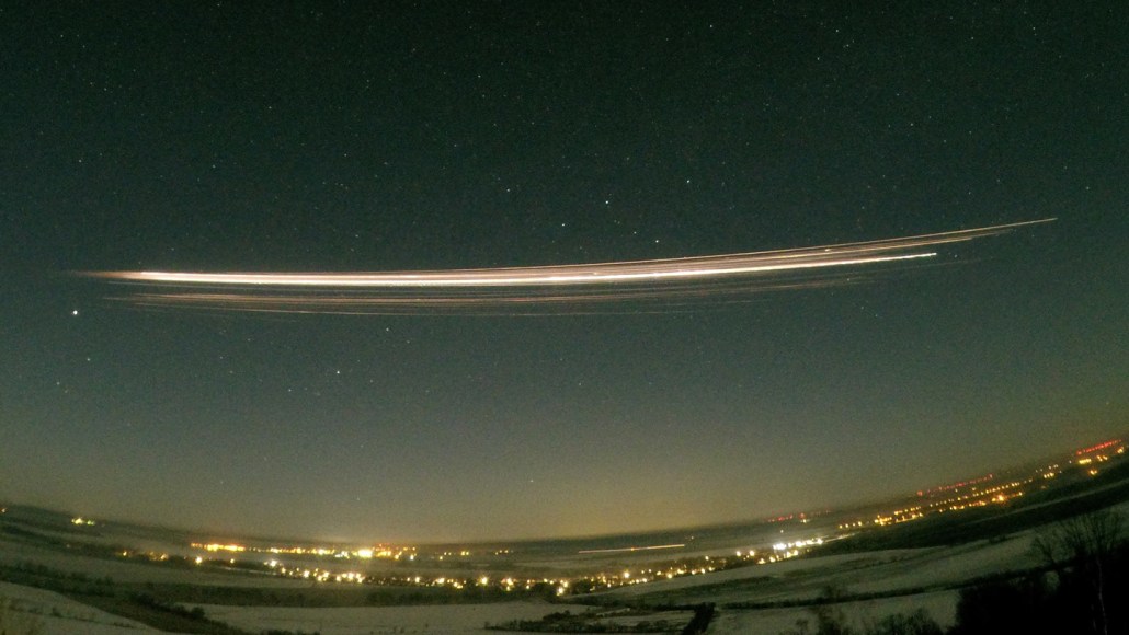 A night sky photograph showing multiple glowing fragments moving along a similar path during a reentry event