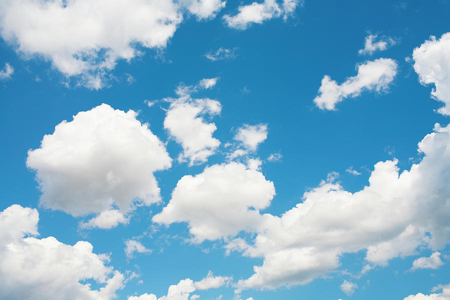 Deep blue daytime sky with a few small white clouds and bright sunlight